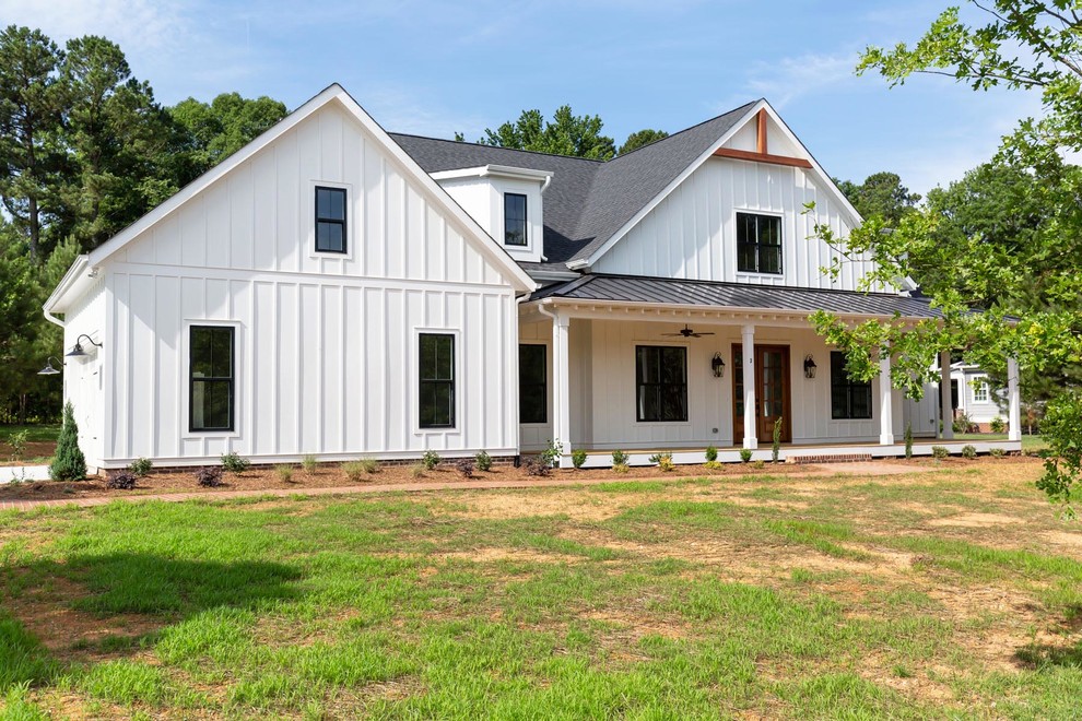 Großes, Zweistöckiges Landhaus Einfamilienhaus mit Metallfassade, weißer Fassadenfarbe, Satteldach und Schindeldach in Raleigh