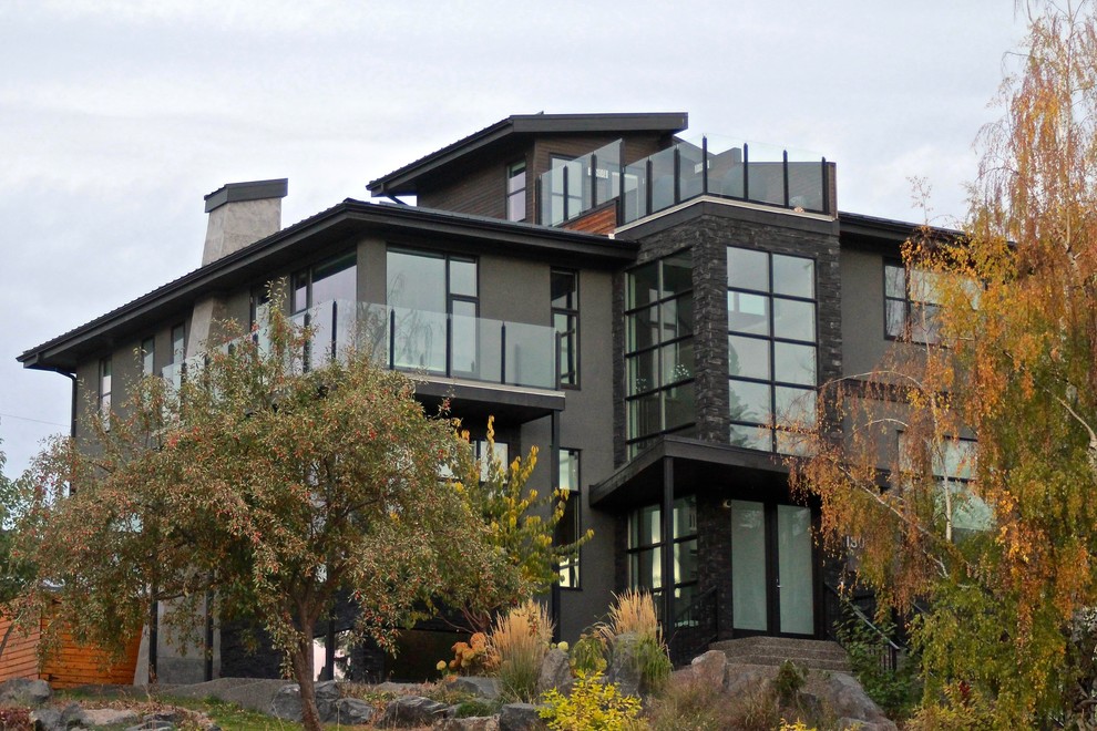 Стильный дизайн: большой, трехэтажный, серый частный загородный дом в современном стиле с облицовкой из цементной штукатурки, односкатной крышей и металлической крышей - последний тренд