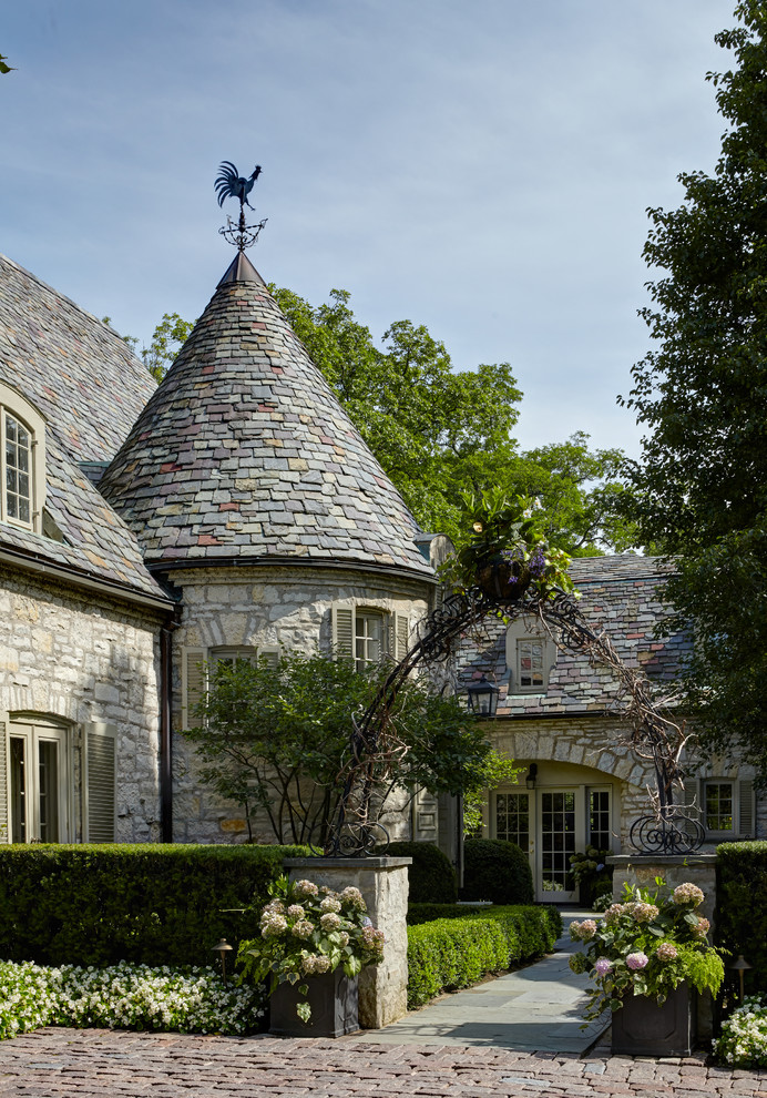 Large traditional beige two-story stone gable roof idea in Chicago
