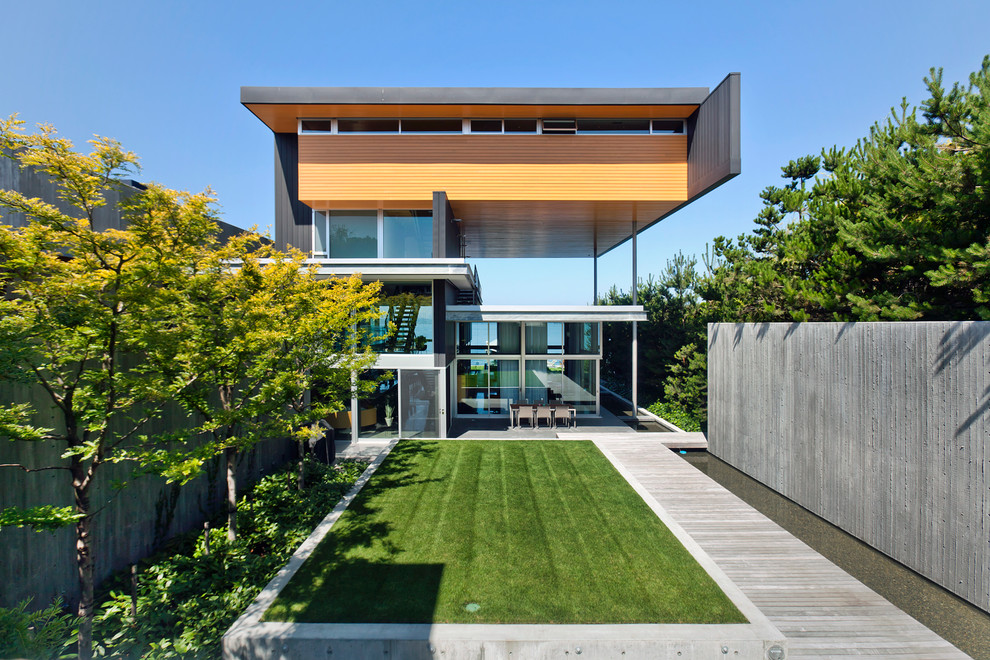Foto de fachada minimalista de tres plantas con revestimientos combinados y tejado plano