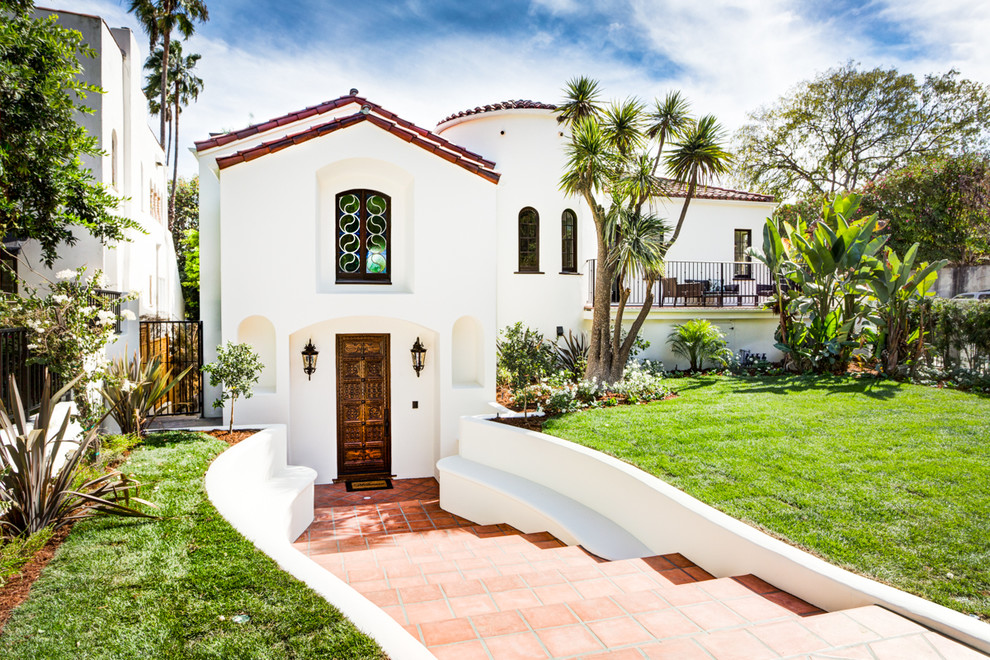 Großes, Zweistöckiges Mediterranes Haus mit Lehmfassade, weißer Fassadenfarbe und Walmdach in Los Angeles
