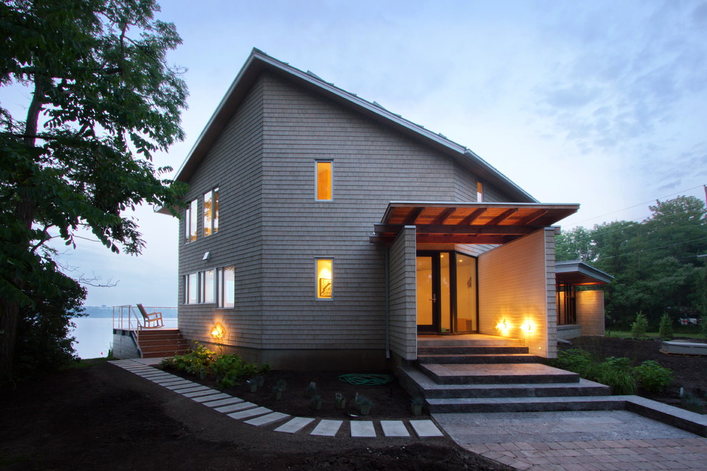 Diseño de fachada gris minimalista de dos plantas con revestimiento de madera y tejado a dos aguas