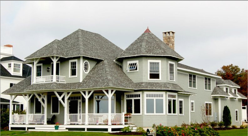 Foto de fachada de casa gris clásica renovada grande de dos plantas con revestimiento de madera, tejado a cuatro aguas y tejado de teja de madera