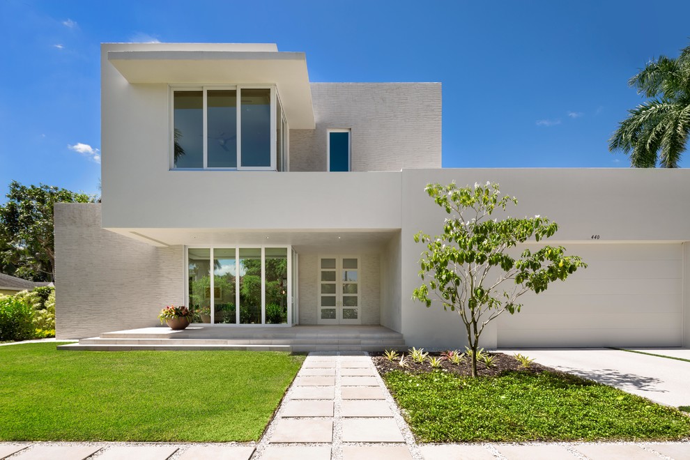 Photo of a large and white modern two floor render detached house in Miami with a flat roof.