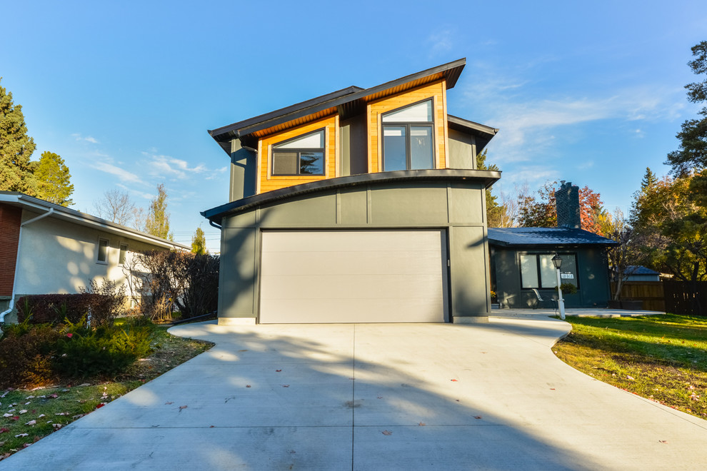 This is an example of a medium sized and gey modern two floor detached house in Calgary with mixed cladding, a flat roof and a mixed material roof.
