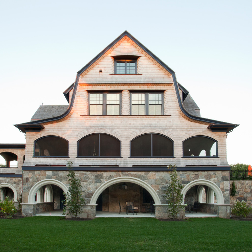 Diseño de fachada de casa beige campestre extra grande de tres plantas con revestimiento de madera, tejado a doble faldón y tejado de teja de madera