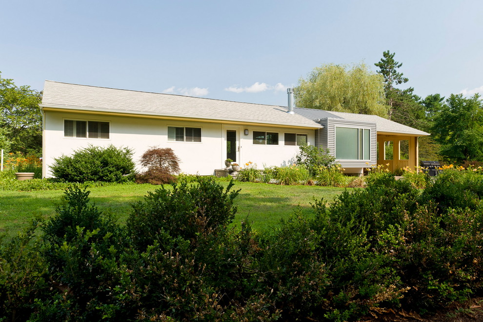 На фото: маленький, одноэтажный, серый дом в стиле модернизм с облицовкой из металла и двускатной крышей для на участке и в саду
