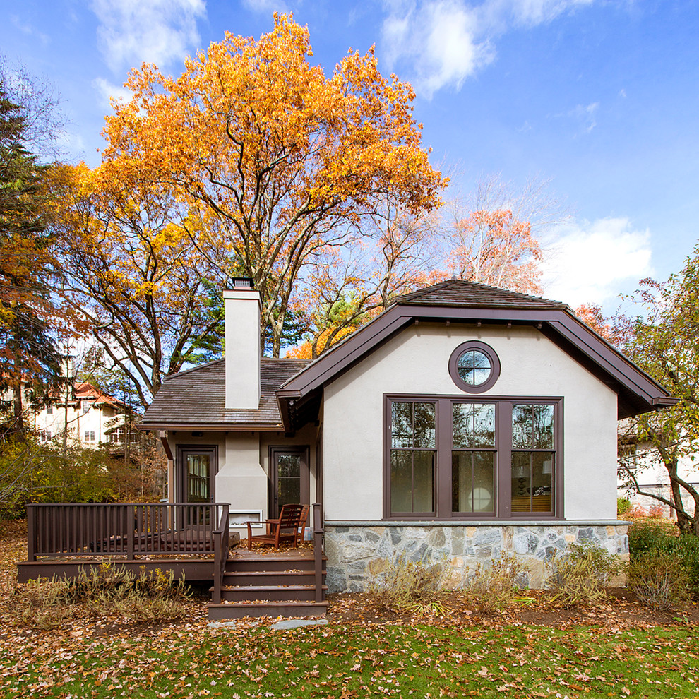 This is an example of a white traditional bungalow house exterior in Boston with a half-hip roof.
