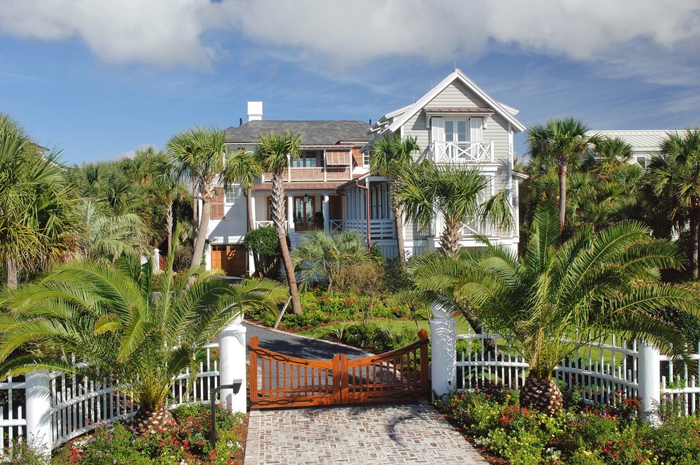 Cette photo montre une grande façade de maison blanche bord de mer en stuc à un étage avec un toit à deux pans.