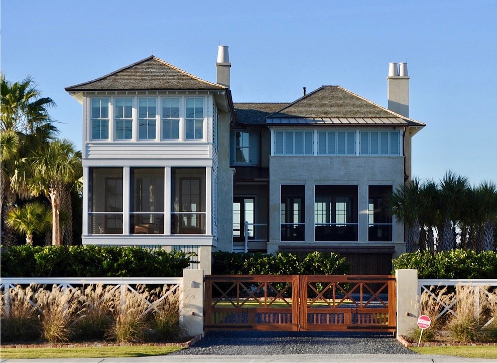 Cette photo montre une façade de maison blanche bord de mer à un étage avec un revêtement mixte et un toit à quatre pans.