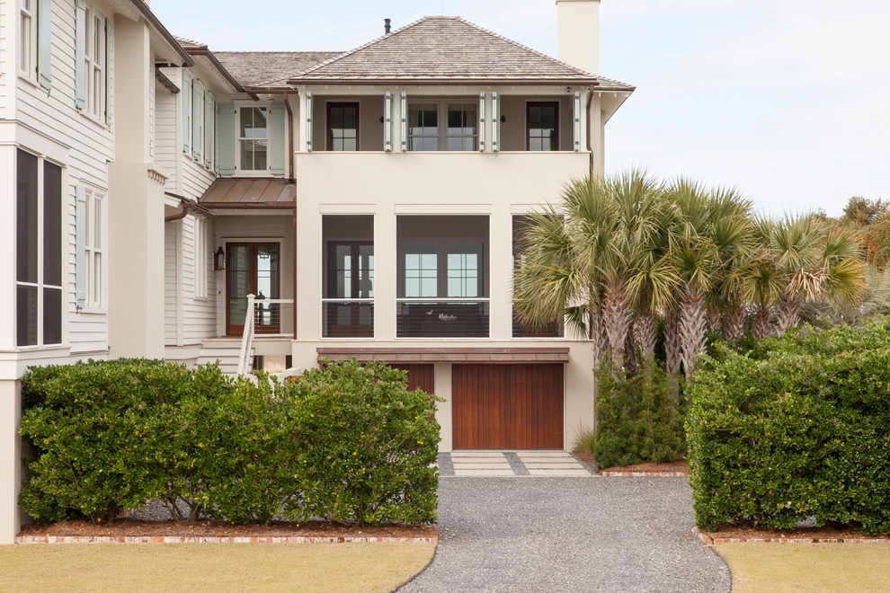 Photo of a white beach style two floor house exterior in Charleston with a hip roof.