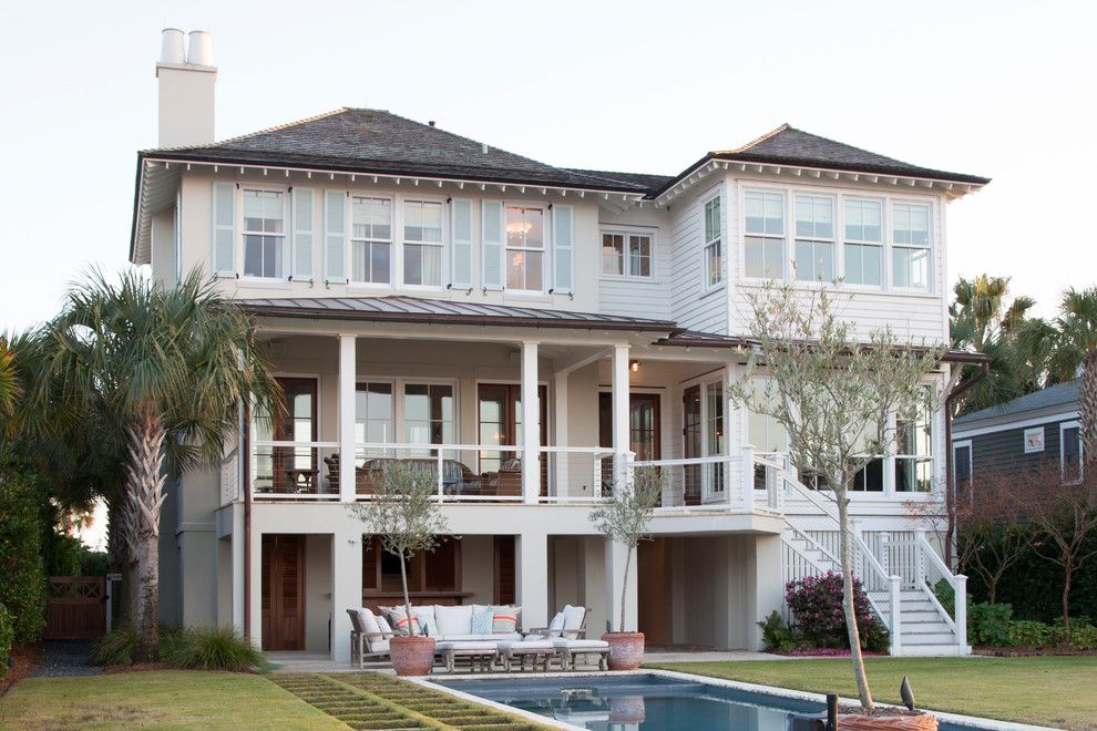 Стильный дизайн: белый, трехэтажный дом в морском стиле с вальмовой крышей - последний тренд