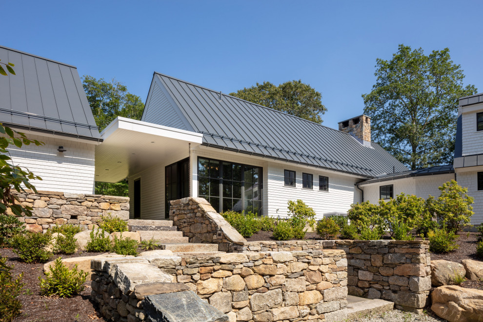 Imagen de fachada de casa blanca de estilo de casa de campo de tamaño medio de dos plantas con revestimiento de madera, tejado a dos aguas y tejado de metal