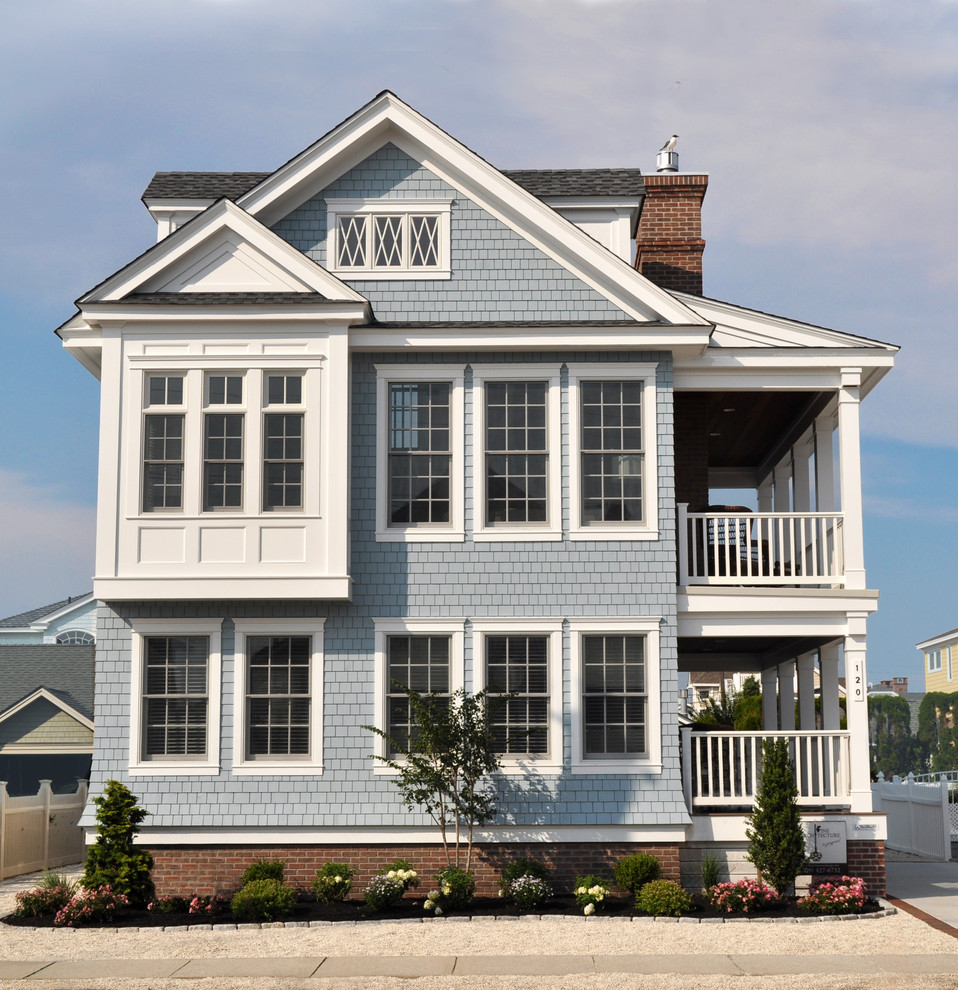 Ispirazione per la villa piccola blu stile marinaro a due piani con rivestimento in legno, tetto a capanna e copertura a scandole