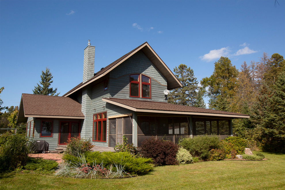 Cette image montre une façade de maison bleue chalet en bois de taille moyenne et à un étage avec un toit à deux pans et un toit en shingle.