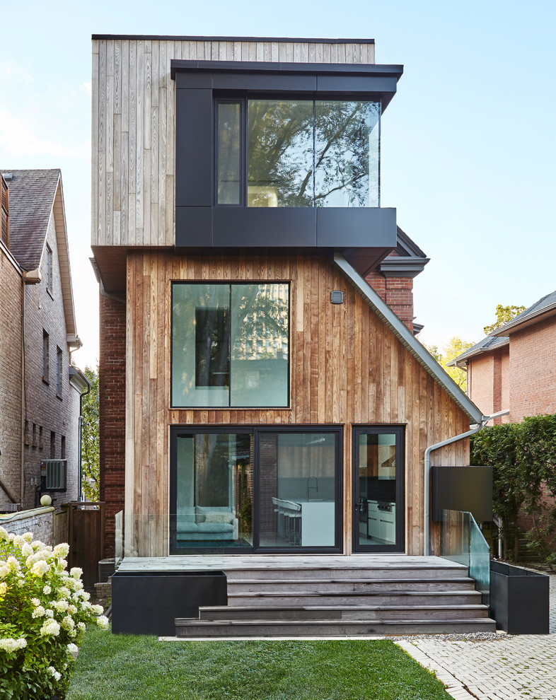 Diseño de fachada de casa multicolor actual de tres plantas con revestimientos combinados y tejado plano