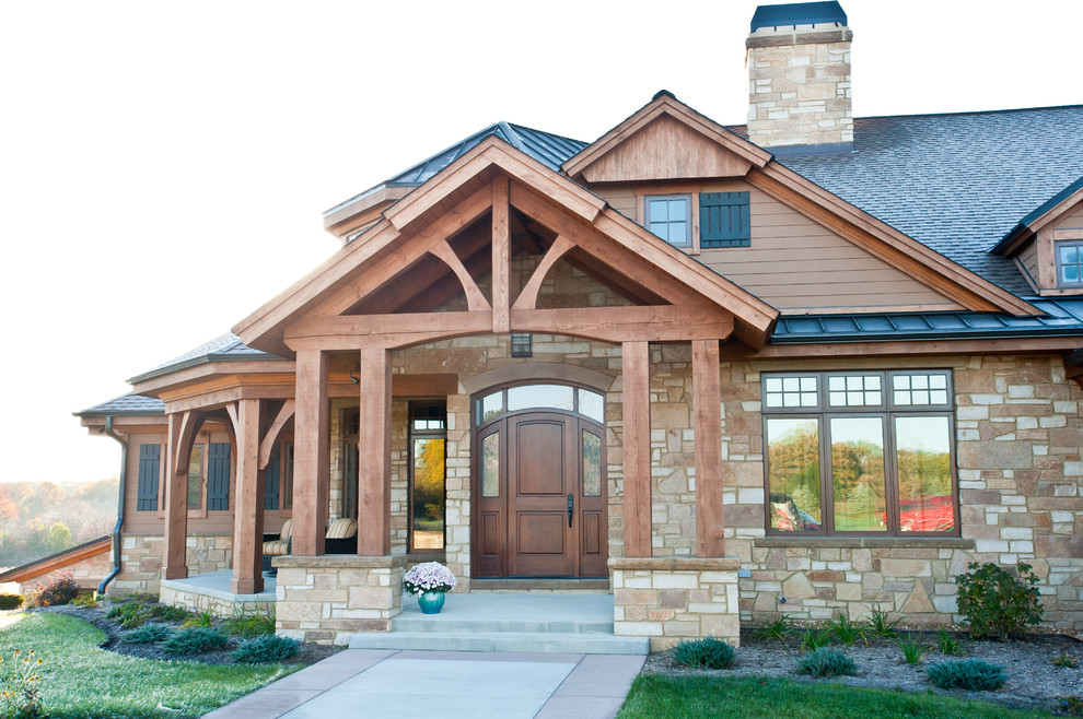 Photo of a large and brown traditional bungalow house exterior in Milwaukee with stone cladding.