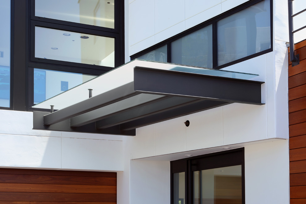 Diseño de fachada de casa blanca minimalista grande de tres plantas con revestimientos combinados y tejado plano