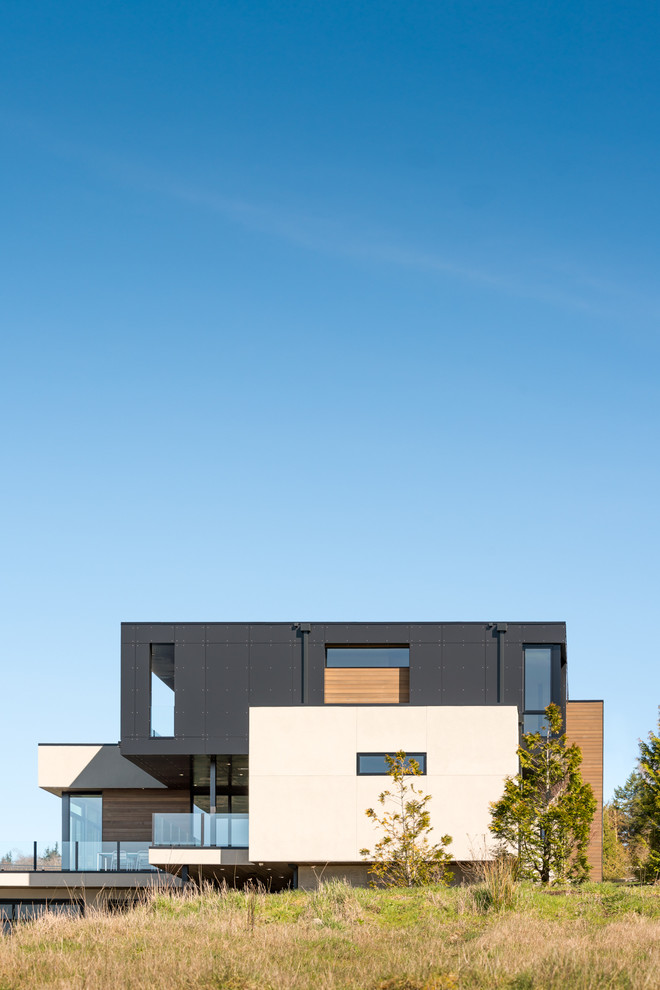 Modelo de fachada negra actual grande de tres plantas con revestimiento de estuco y tejado plano
