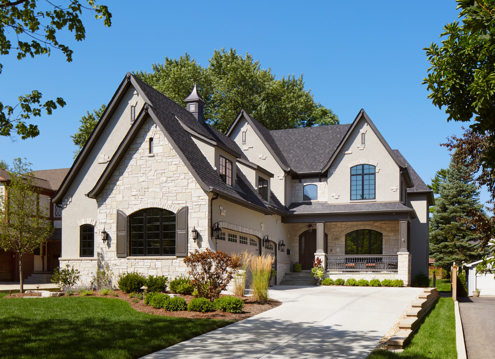 Diseño de fachada beige de estilo americano grande de tres plantas con tejado a dos aguas y revestimientos combinados