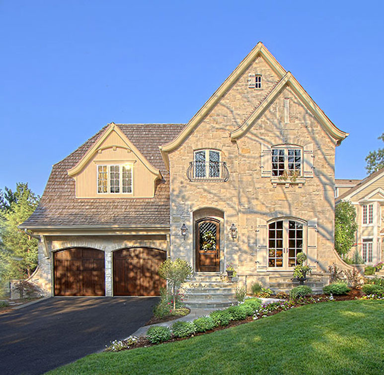 Example of a large classic beige three-story stone exterior home design in Chicago with a clipped gable roof