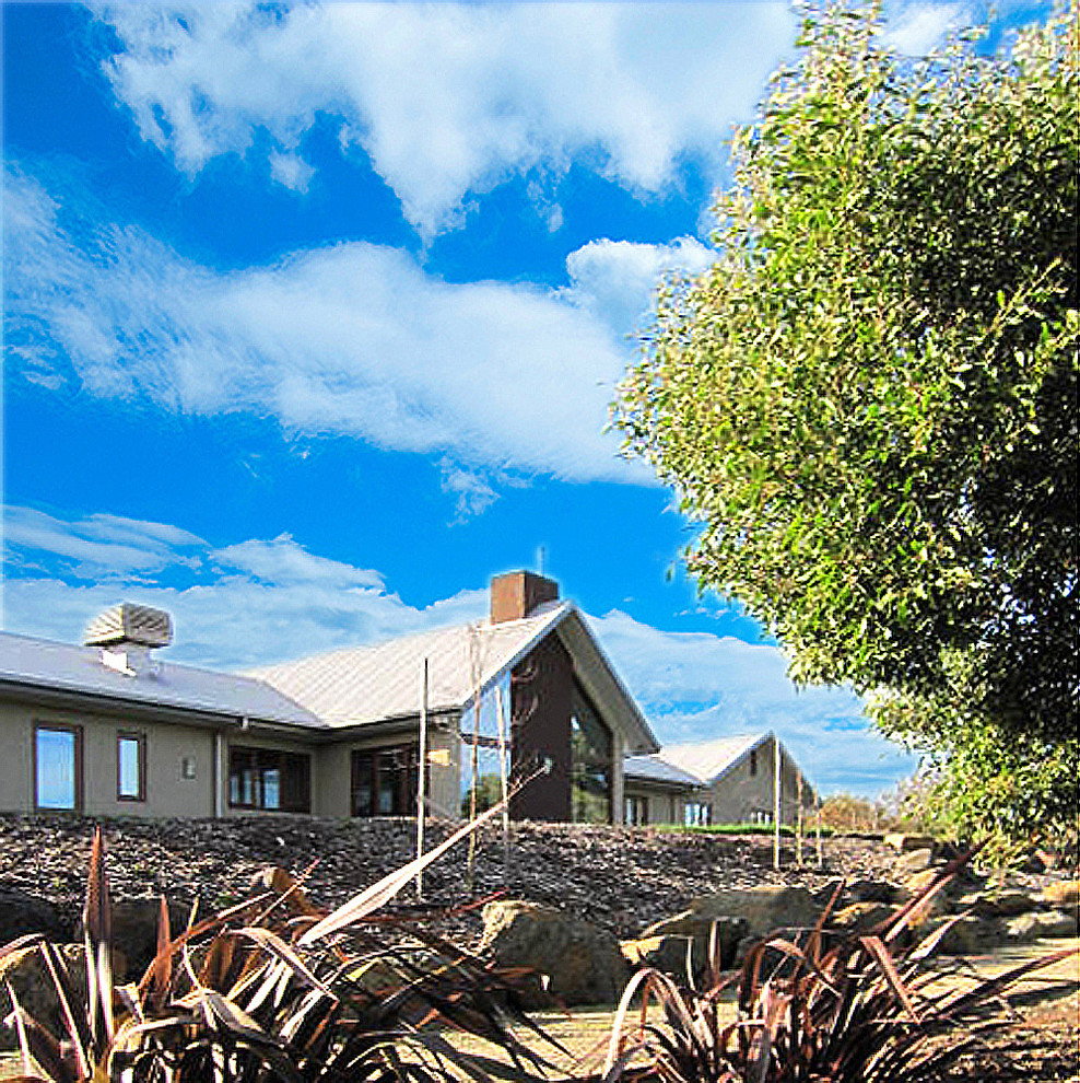 Ejemplo de fachada beige de estilo de casa de campo extra grande de una planta con revestimiento de hormigón y tejado a dos aguas