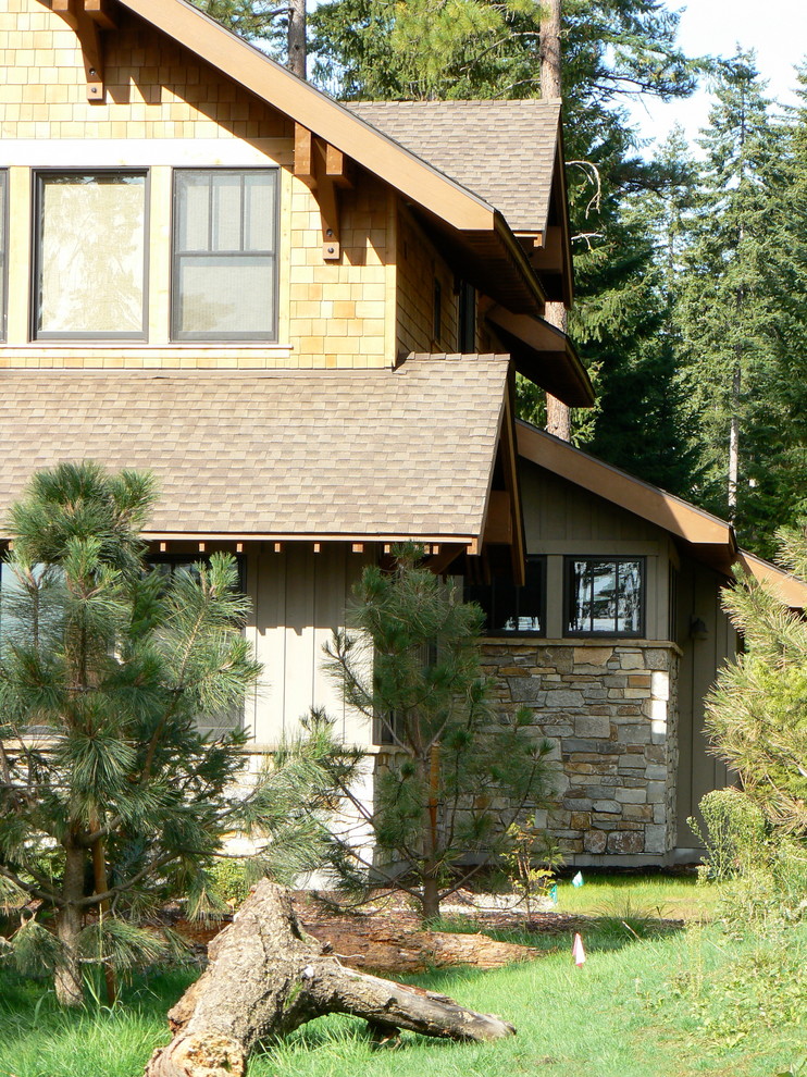 Foto della facciata di una casa rustica a due piani di medie dimensioni con rivestimenti misti e tetto a capanna