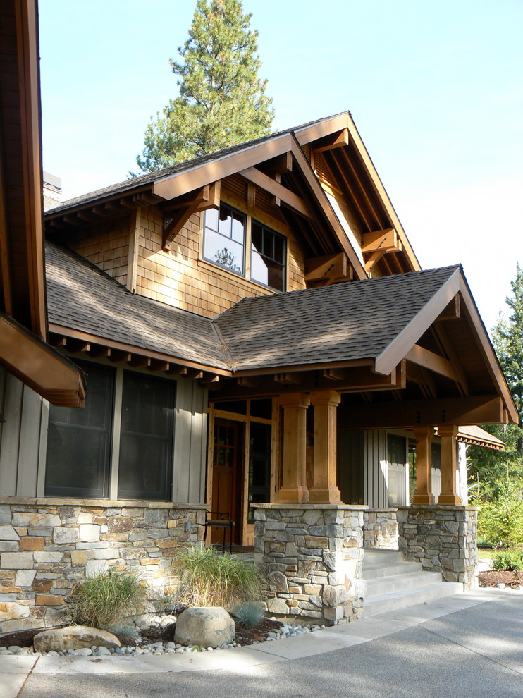 На фото: двухэтажный дом среднего размера в стиле рустика с комбинированной облицовкой и двускатной крышей для охотников