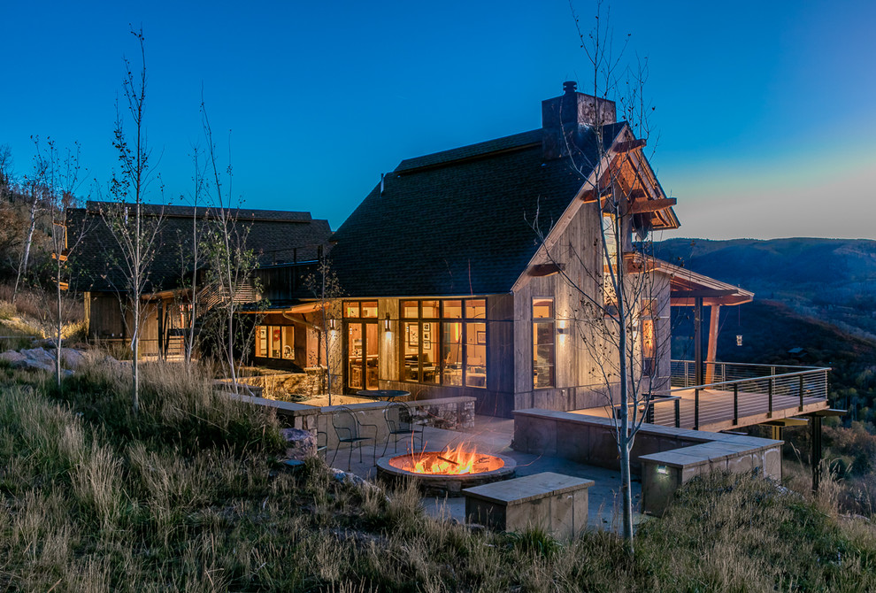 Photo of a large and gey rustic house exterior in Denver with a pitched roof and wood cladding.