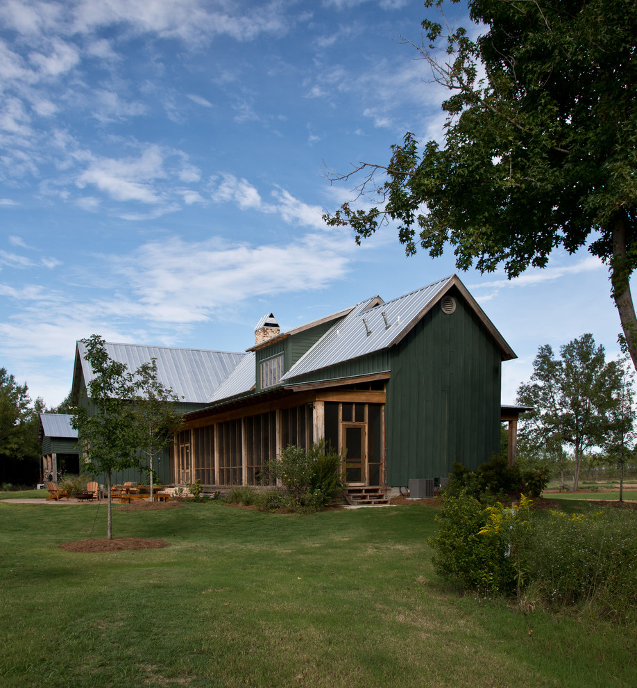 На фото: деревянный, зеленый дом в стиле кантри с двускатной крышей и металлической крышей