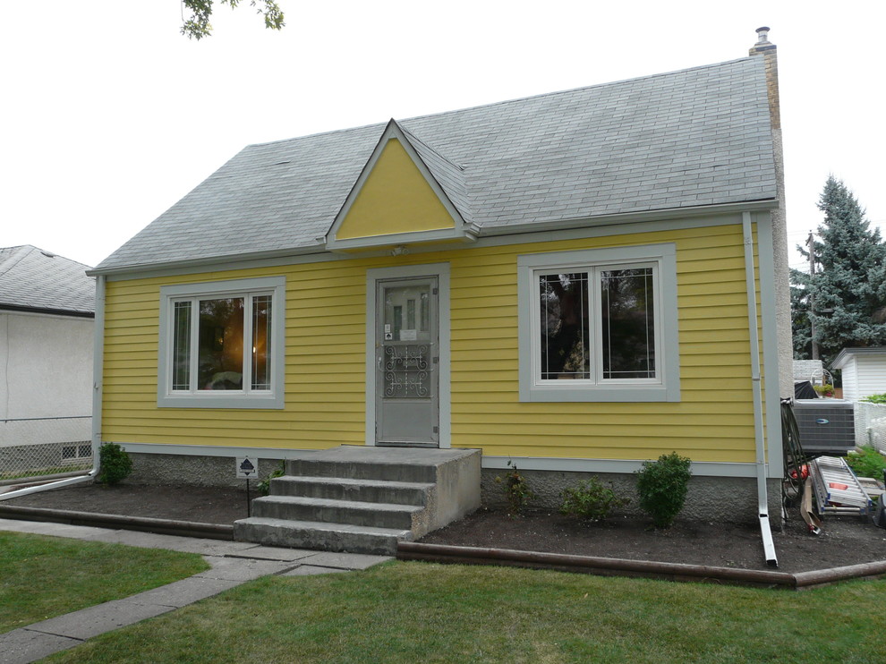 Стильный дизайн: маленький, одноэтажный, деревянный, желтый частный загородный дом в классическом стиле с двускатной крышей и крышей из гибкой черепицы для на участке и в саду - последний тренд