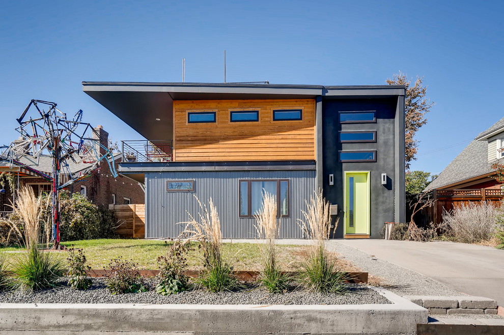 Réalisation d'une façade de maison grise design de taille moyenne et à un étage avec un revêtement mixte et un toit plat.