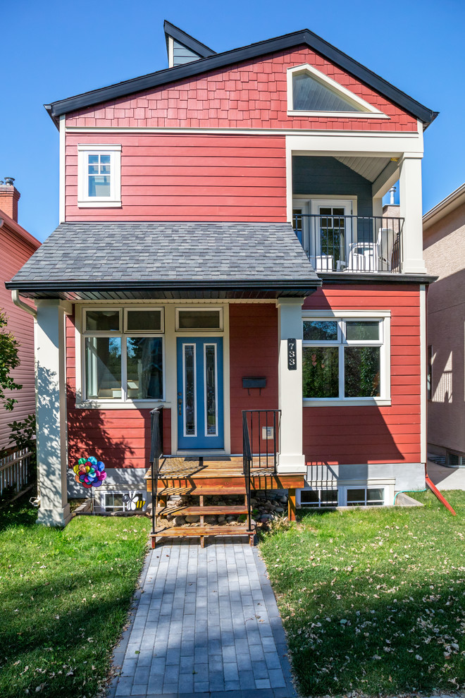 Design ideas for a medium sized and red traditional two floor detached house in Calgary with wood cladding, a pitched roof and a shingle roof.