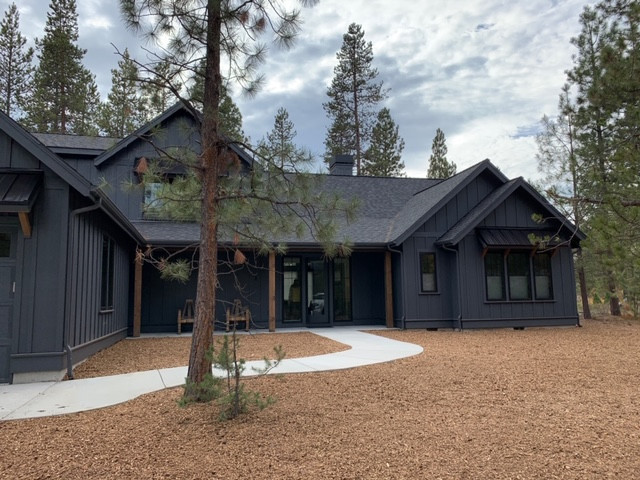 Photo of a large and black rural two floor detached house in Salt Lake City with wood cladding, a pitched roof and a mixed material roof.