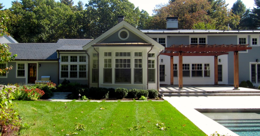 На фото: синий дом в стиле неоклассика (современная классика) с двускатной крышей