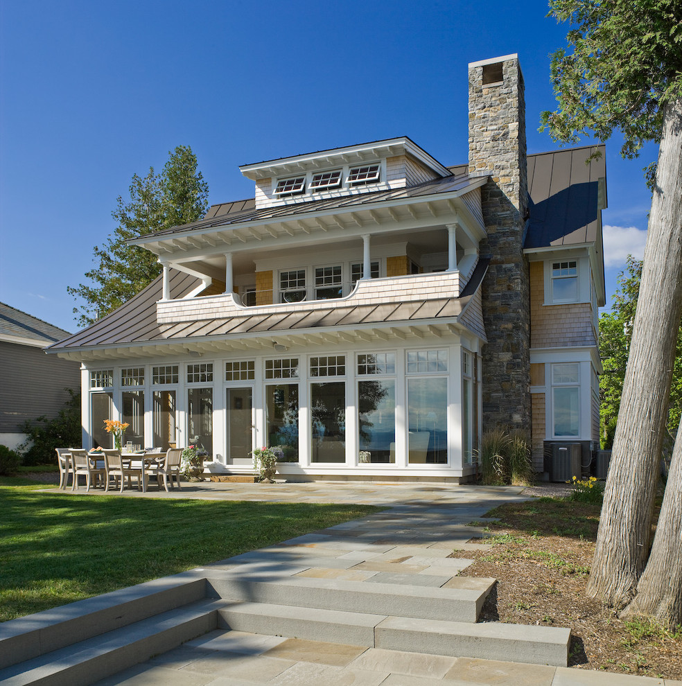 Idée de décoration pour une grande façade de maison marine en bois à un étage.