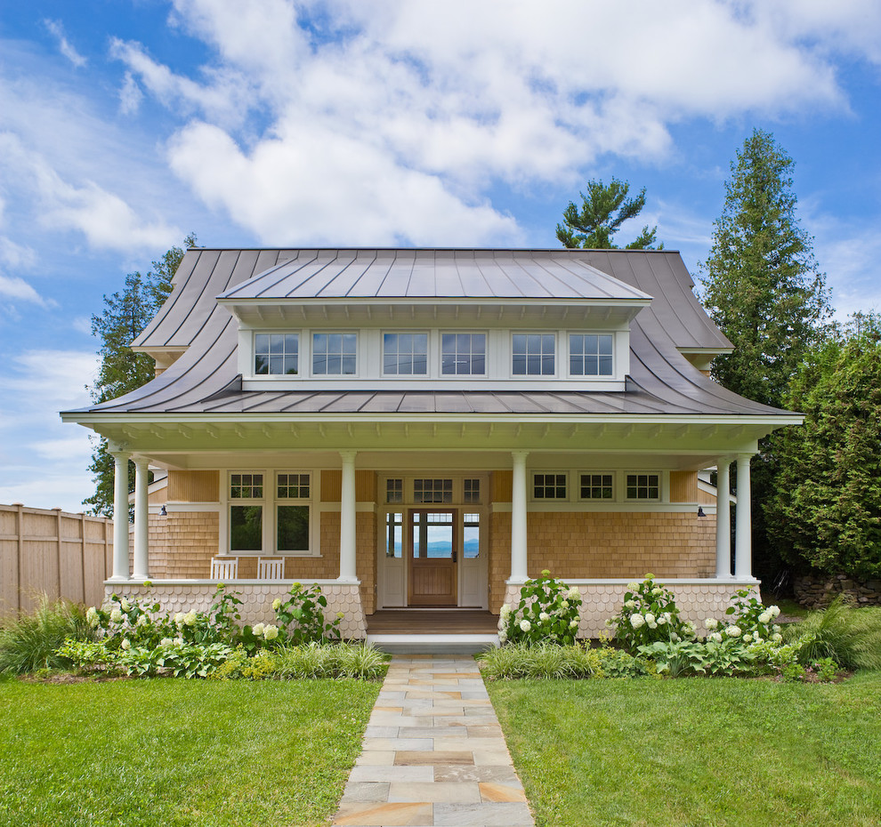 Photo of a large coastal two floor detached house in Burlington with wood cladding and a metal roof.