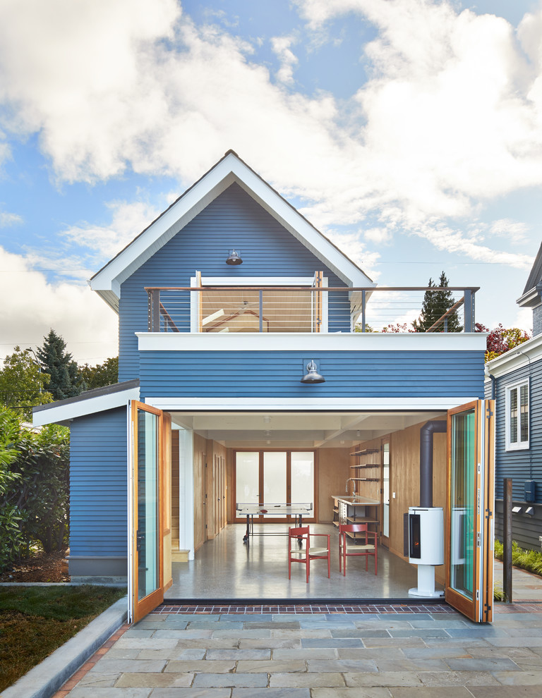 Esempio della villa piccola blu contemporanea a due piani con rivestimento in legno, tetto a capanna e copertura a scandole
