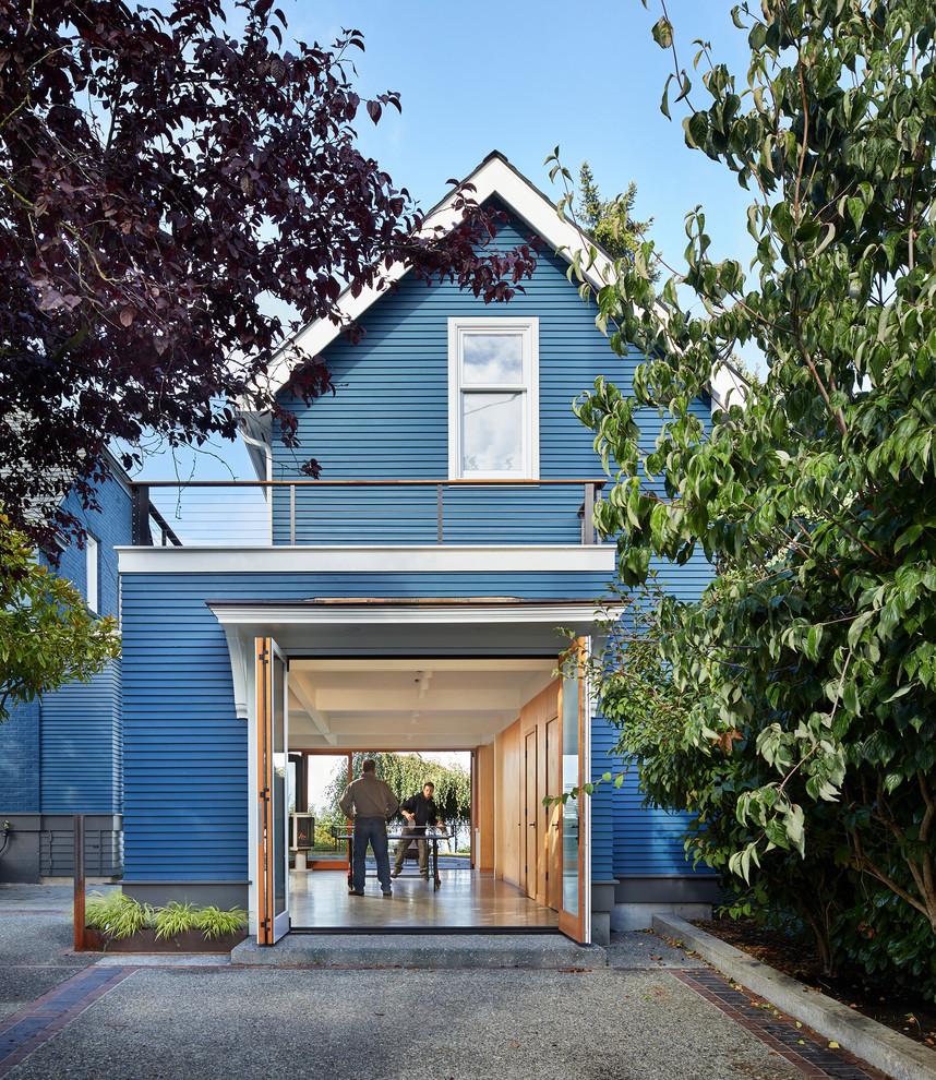 Réalisation d'une petite façade de maison bleue design en bois à un étage avec un toit à deux pans et un toit en shingle.