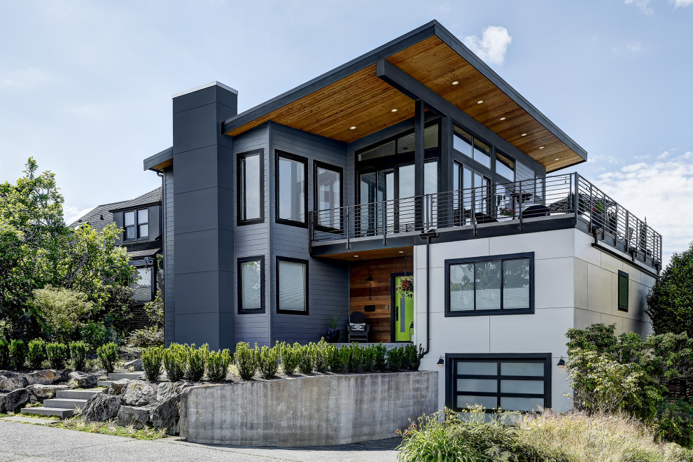 Diseño de fachada de casa gris actual grande de dos plantas con revestimiento de aglomerado de cemento y tejado de un solo tendido