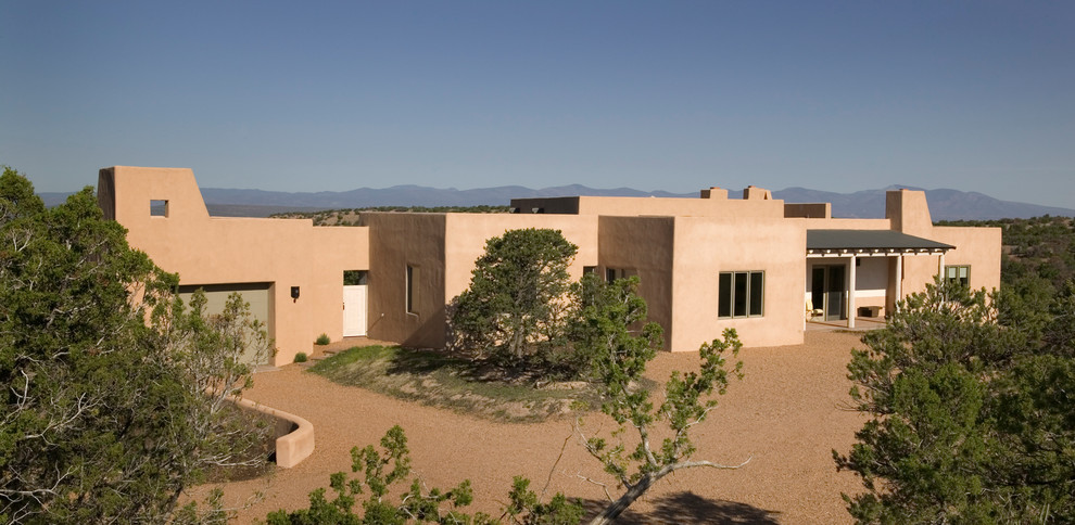 Diseño de fachada beige de estilo americano de tamaño medio de una planta con revestimiento de estuco y tejado plano