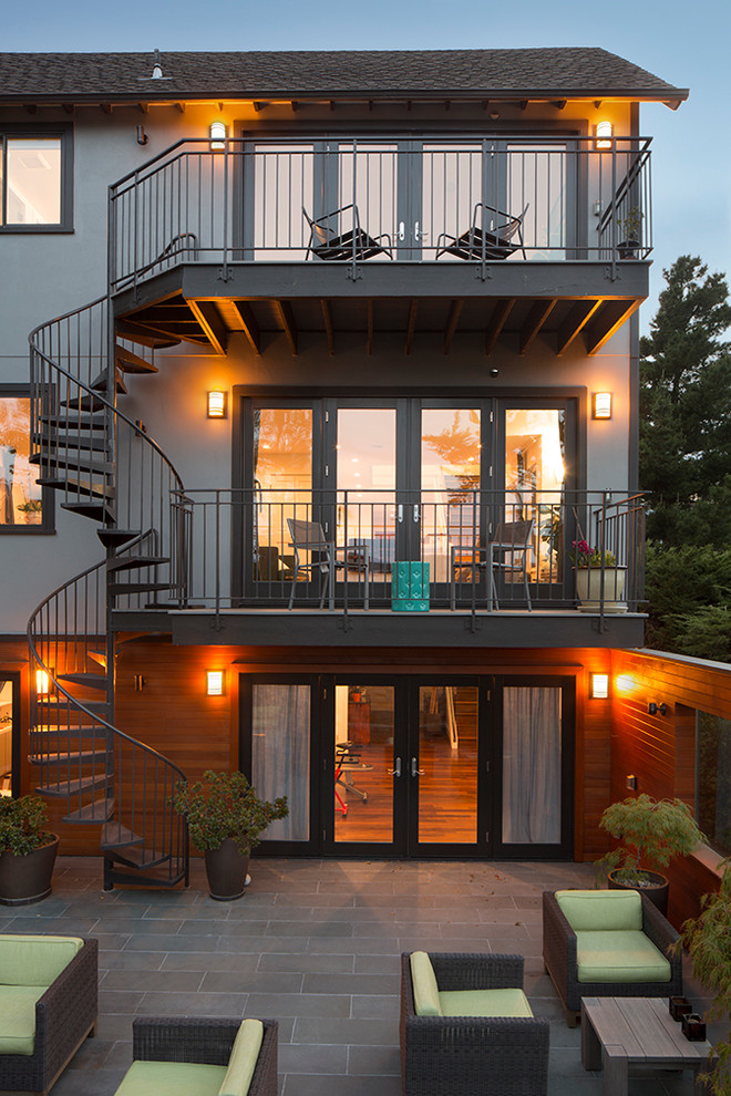 Réalisation d'une grande façade de maison grise minimaliste en stuc à deux étages et plus avec un toit à deux pans.