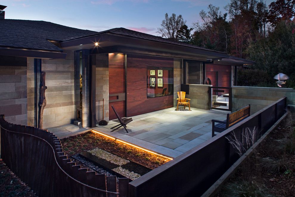 Imagen de fachada de casa gris minimalista grande con revestimiento de piedra, tejado a cuatro aguas y tejado de teja de madera
