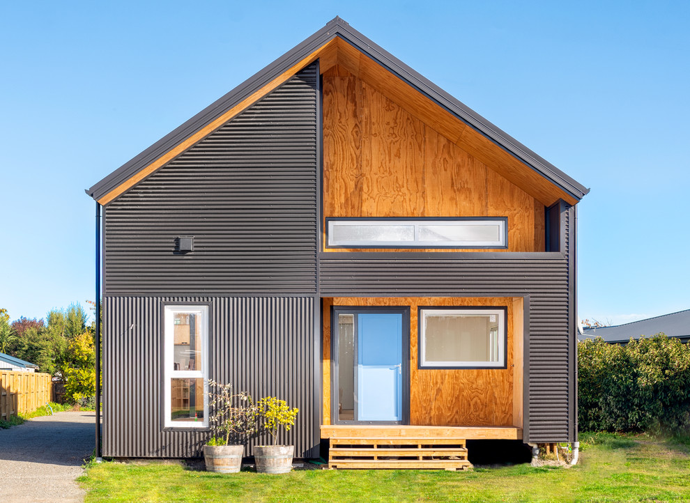 Inspiration för små moderna grå hus, med två våningar, metallfasad och sadeltak