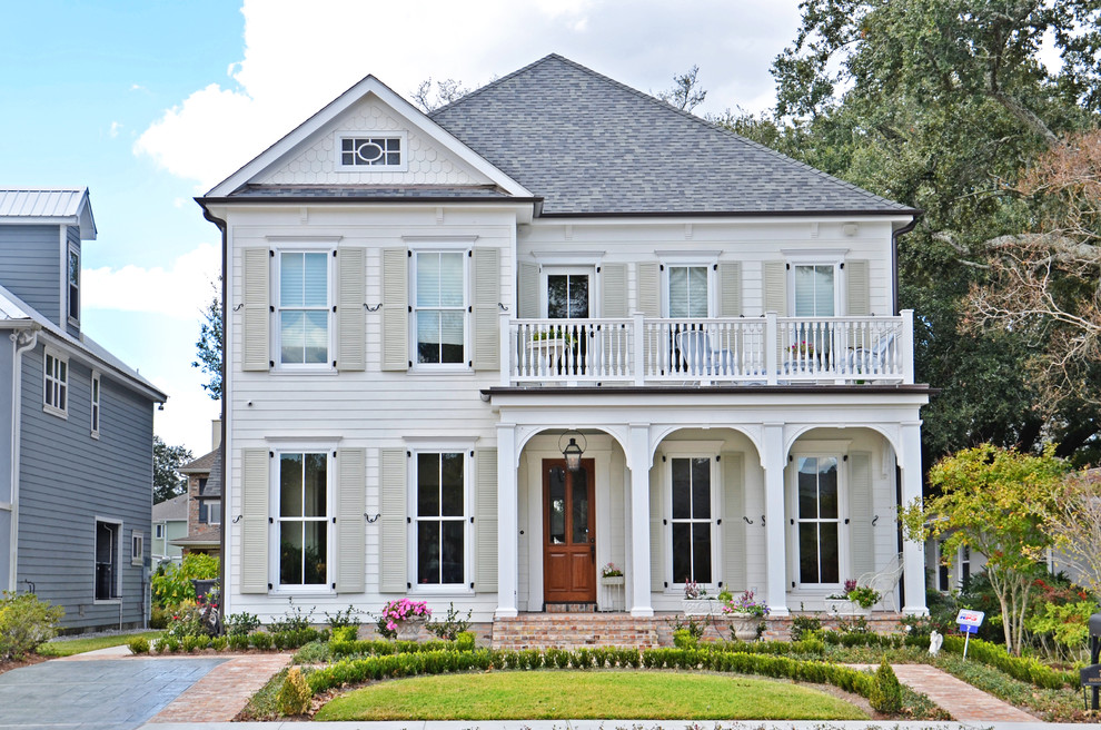 Cette photo montre une façade de maison blanche chic en panneau de béton fibré de taille moyenne et à un étage.