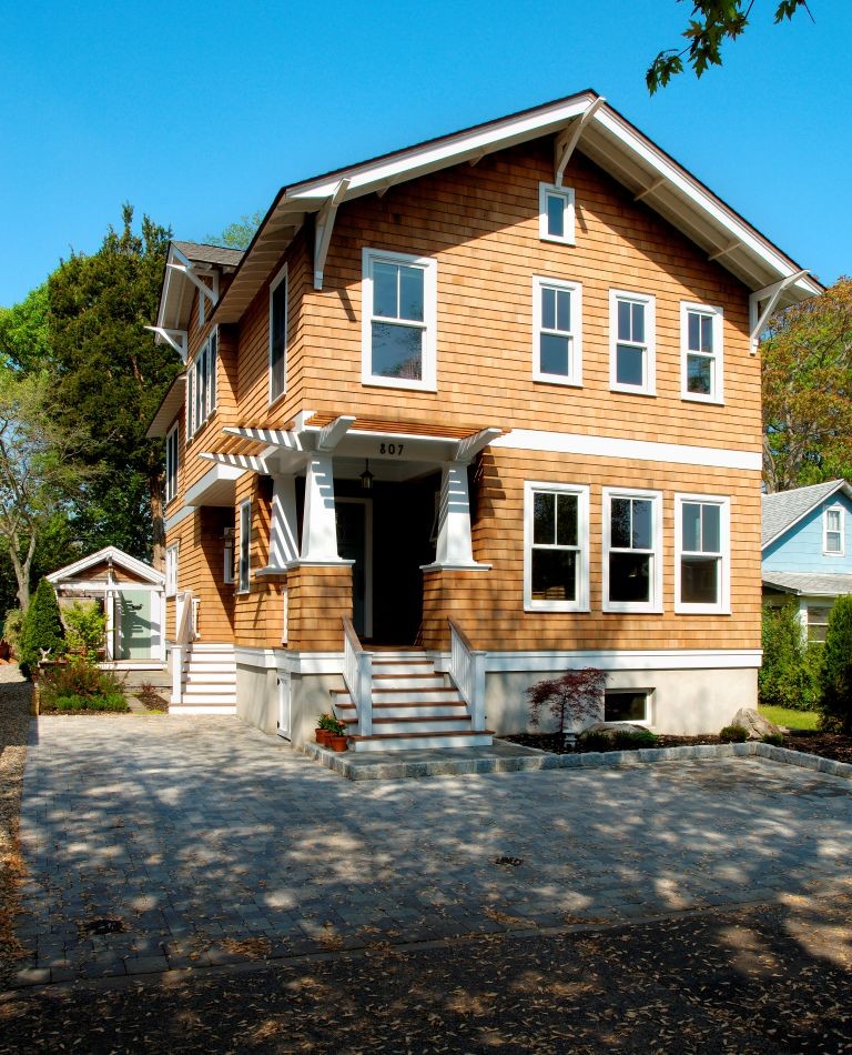 Imagen de fachada de casa marrón de estilo americano de tamaño medio de dos plantas con revestimiento de madera, tejado a dos aguas y tejado de teja de madera