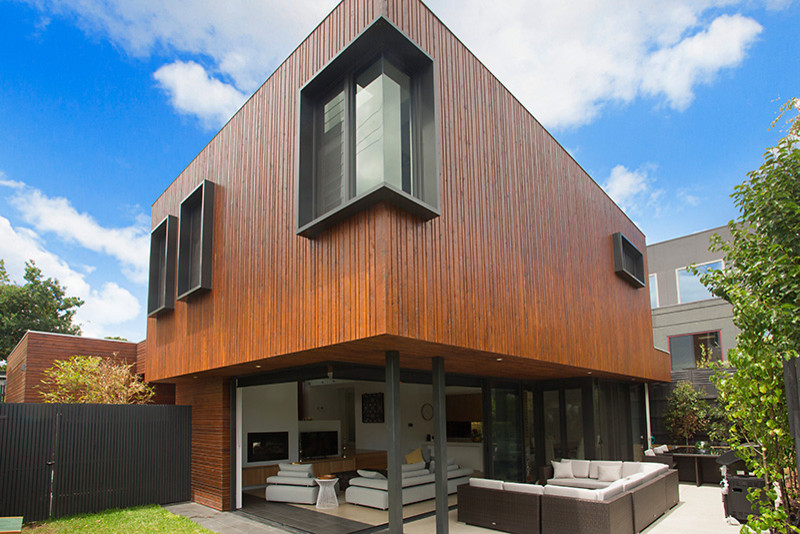 На фото: большой, двухэтажный, деревянный, разноцветный частный загородный дом в современном стиле с плоской крышей с