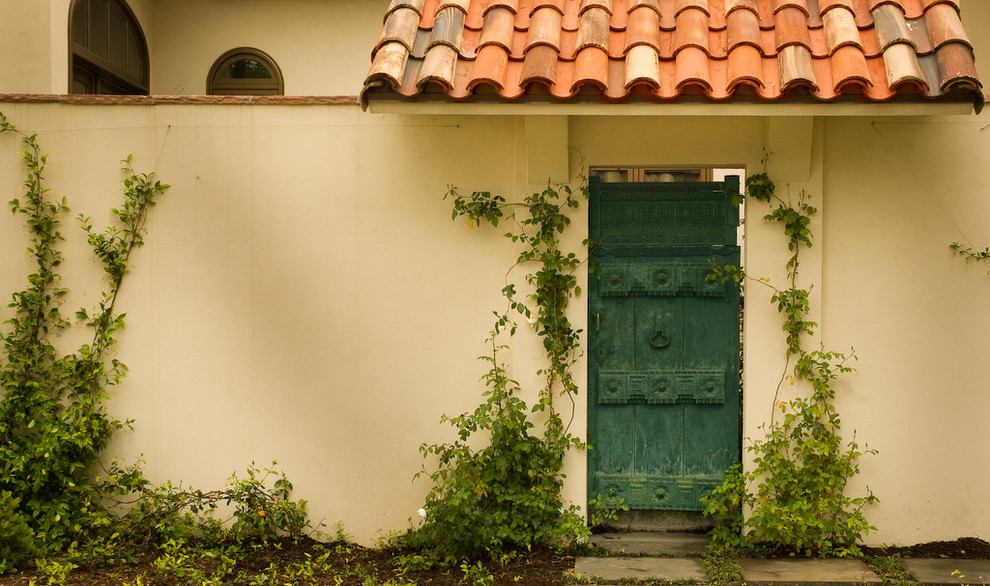 Diseño de fachada de casa beige mediterránea de tamaño medio de dos plantas con revestimiento de estuco y tejado de teja de barro