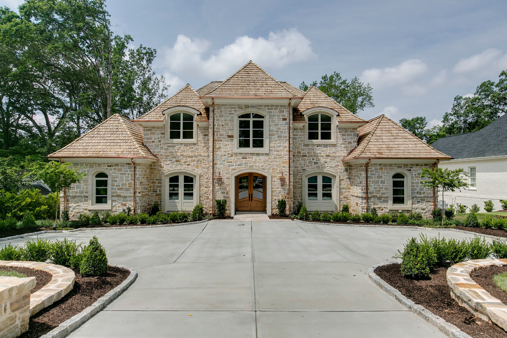Inspiration for a beige classic two floor house exterior in Raleigh with stone cladding and a hip roof.