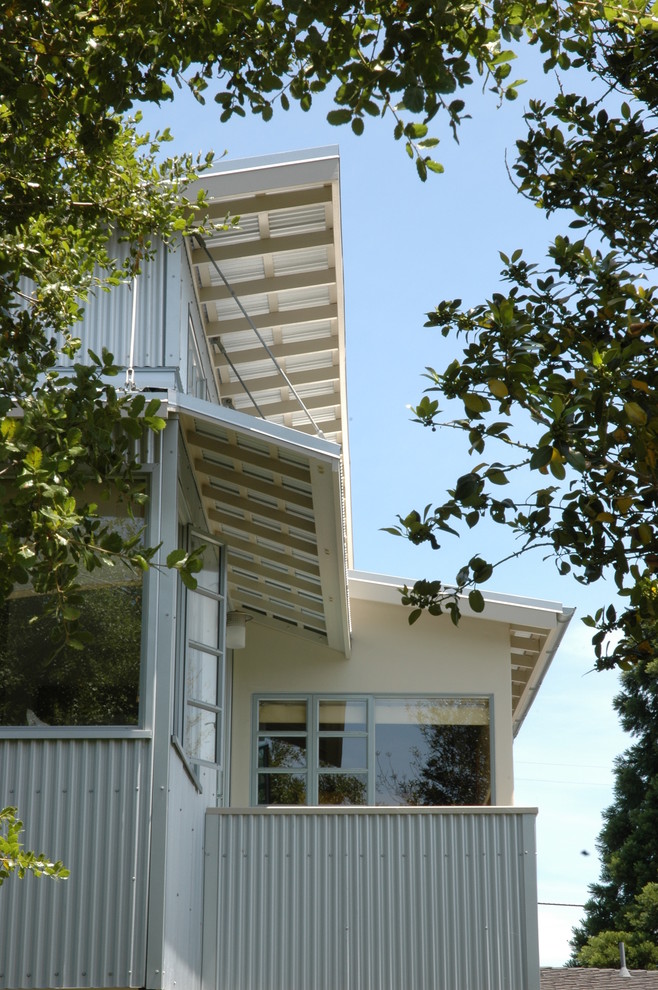 Inspiration pour une grande façade de maison beige et métallique bohème à un étage avec un toit plat.